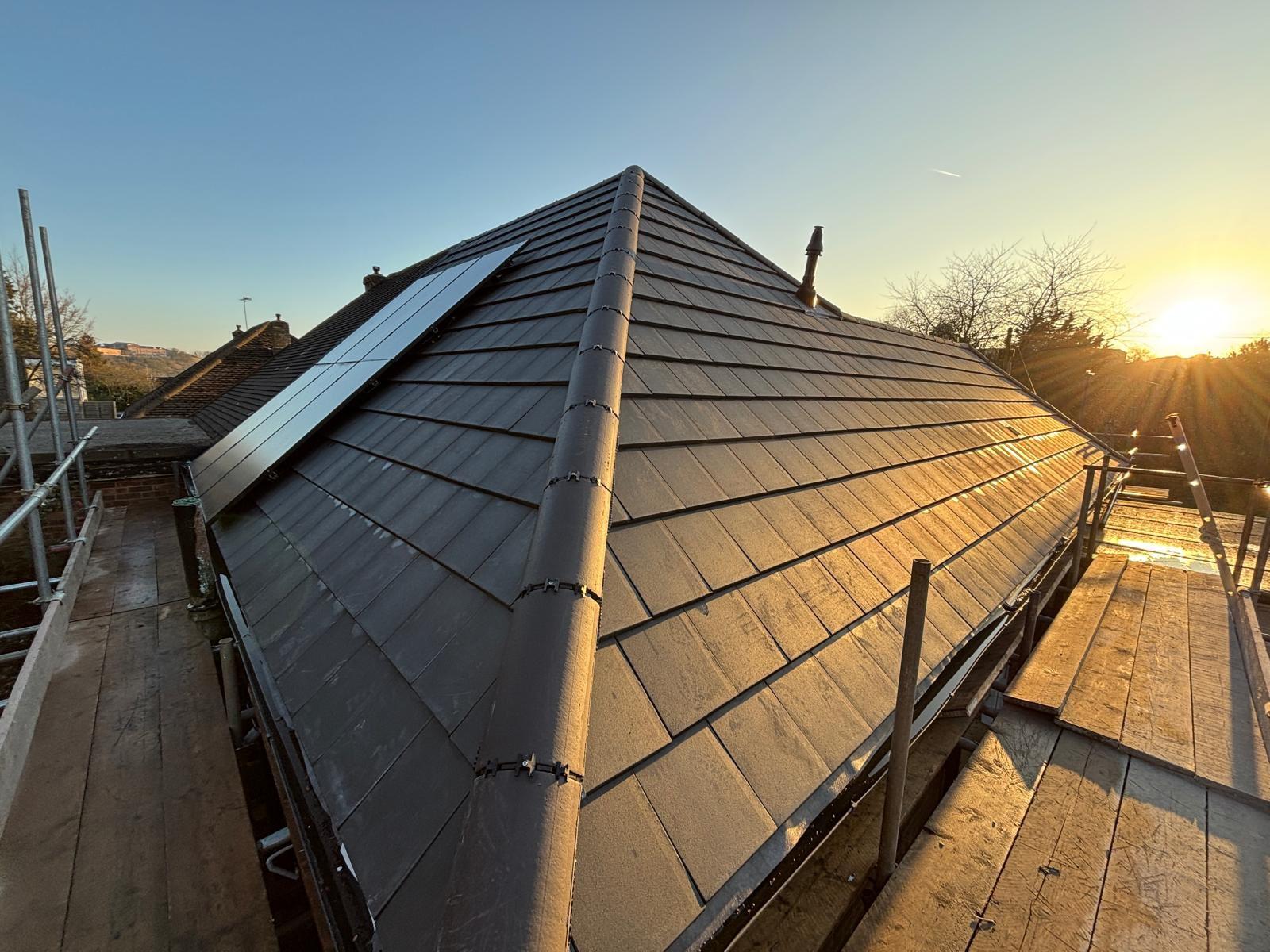 Roofer setting out ridgeline on a new slate roof in Suffolk